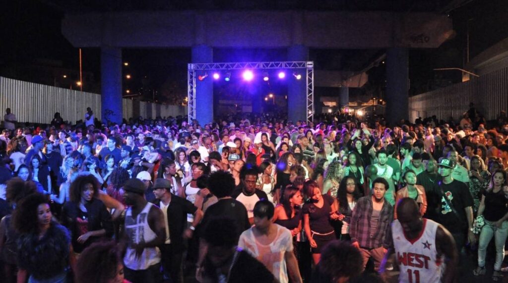 Pista de dança lotada com pessoas dançando charme na Festa Madureira Disco Clube.