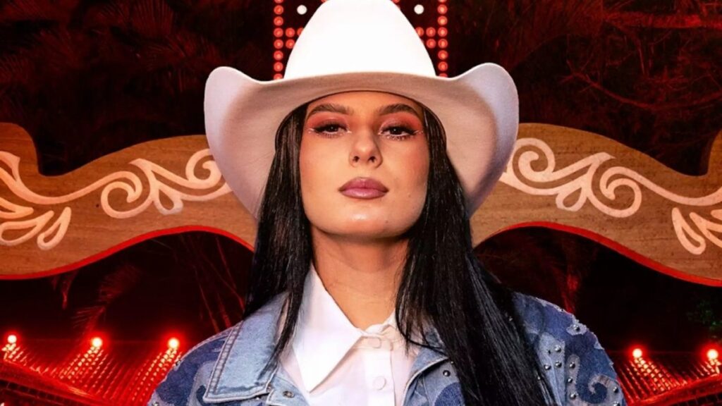 Ana Castela em show ao vivo, animando a plateia com sua música sertaneja