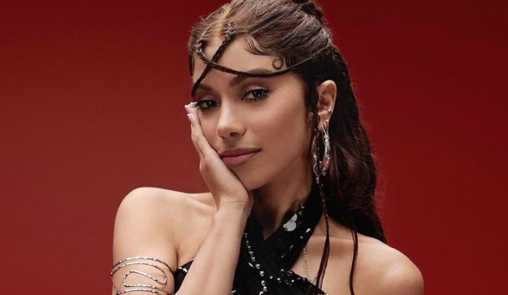Anitta durante a apresentação da Equilibrivm Tour, com detalhes de pesquisa de ingressos.