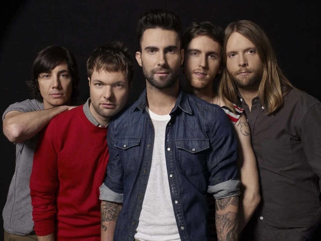 Maroon 5 ao vivo durante um show, com multidão animada em uma apresentação